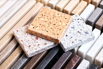 Porcelain three stoneware artificial stone square samples laid on kitchen countertop examples of...