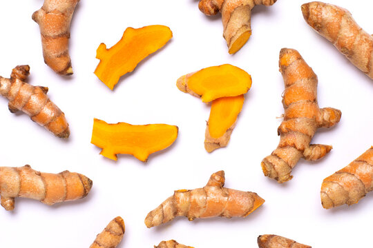 Turmeric root with slices isolated on white background. Top view, flat lay.