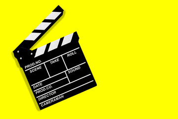 Fototapeta na wymiar Movie clapperboard for shooting videos and movies on a yellow background copy space