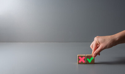 pros and cons or for and against concept , green check mark and a red cross on wooden blocks ,...