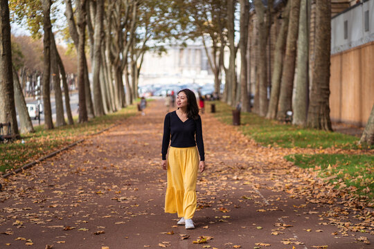 Woman walking along path between fence