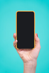 One Hand holding new smartphone with black screen isolate on over blue background in vertical view