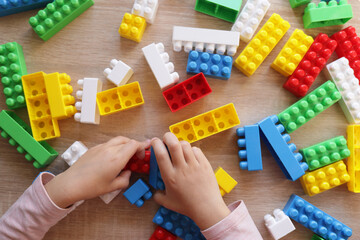 child builds a house from a constructor, top view. The concept of education, early development of children