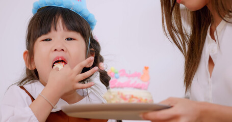 Mother gave her lovely daughter a birthday cake.