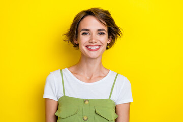 Portrait photo of young lady wear khaki overalls toothy beaming smile enjoy her lifestyle after clinic done veneers isolated on yellow color background