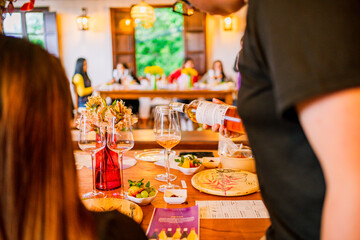 man serving wine to a woman in a crystal glass, in a country house