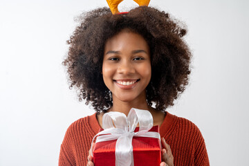 Portrait of young attractive african american woman with curly hair and reindeer antlers hairband...