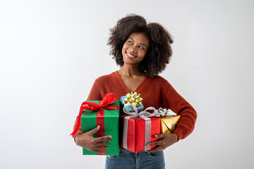 Portrait of young attractive african american woman with curly hair hugging gift boxes in studio on...