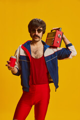 Portrait of man with moustache posing in vintage sportswear and red cycling shorts isolated over...
