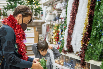 grandmother and grandchild buying christmas tree decorations at the supermarket