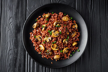 delicious red rice with mushrooms on a black wooden rustic background