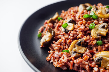 delicious red rice with mushrooms on a white background