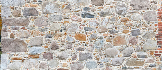 Rustic natural stone wall in panorama format.