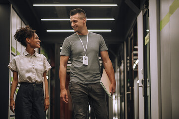 Two smiling cheerful datacenter employees talking on the go