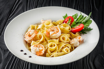 delicious shrimp fettuccine alfredo pasta on a black rustic background