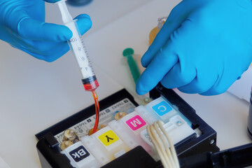 Printer maintenance. Master fills inkjet printer with ink or syringe paint. Hands with gloves...