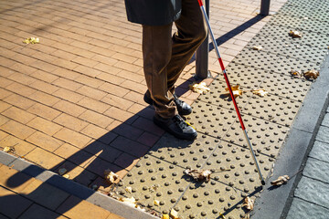 Close-up of a blind man with a walking stick. Detects tactile tiles for self-orientation while...