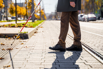 Close-up of a blind man with a walking stick. Detects tactile tiles for self-orientation while moving through the streets of the city