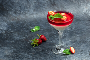 Traditional Italian dessert panna cotta with strawberry jelly on a dark background. Summer yogurt dessert. Long banner format. space for text