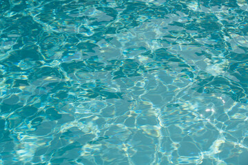 Ripple Water in swimming pool with sun reflection. Wavy water background.