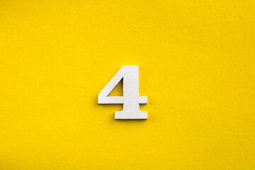 Number 4 - White wooden number on yellow background