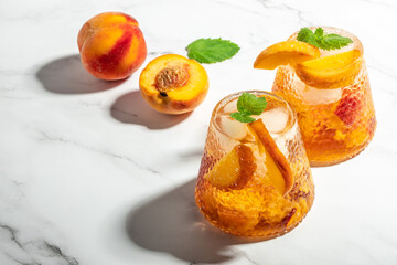 Refreshing Peach Bourbon Smash Cocktail with ice cubes, and mint in glass. Long banner format