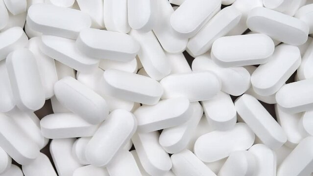 A large group of generic white color medication pills. 
