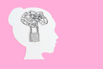 White head silhouette and chained padlock on pink