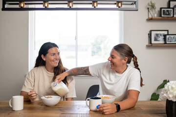 Adult lesbian couple have breakfast together in dining room