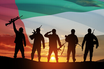 Silhouettes of soldiers on background of UAE flag and the sunset or the sunrise. Concept of national holidays. Commemoration Day.