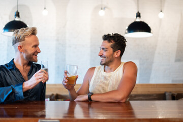 LGBTQ Friends sit at a bar with beer and champagne