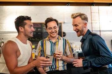 LGBTQ Friends sit at a bar and use a phone
