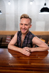 Gay man sits at a bar with champagne