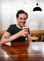 Bisexual man sits at a bar with beer