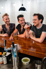 LGBTQ Friends sit at a bar with beer and champagne