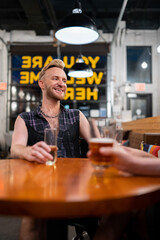 LGBTQ Friends sit at a bar with beer and champagne