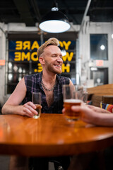 LGBTQ Friends sit at a bar with beer and champagne