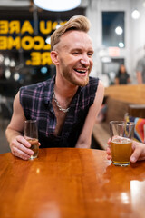 Gay man sits at a bar with champagne