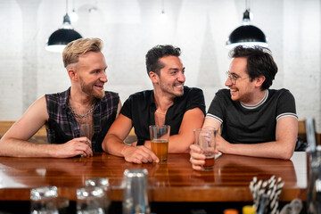 LGBTQ Friends sit at a bar with beer and champagne