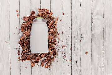 empty shampoo bottle with pecan nut shells on white wooden background