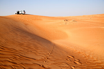 Fototapeta na wymiar Off road vehicle on sand dunes, Oman