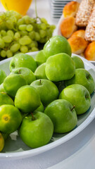Fresh raw fruit, orange juice, apples, grapes, and breads on a modern white kitchen table. Healthy eating. Organic food.