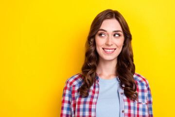 Photo of charming dreamy young lady wear plaid shirt looking empty space isolated yellow color background
