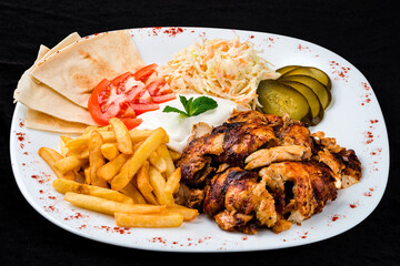 Fried chicken with french fries, coleslaw, tomatoes, pickles, sour cream and pita bread.
