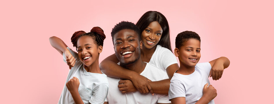 Happy african american family posing on pink studio background