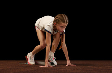 At start line. Portrait of begginer athlete, runner training isolated on black studio background....