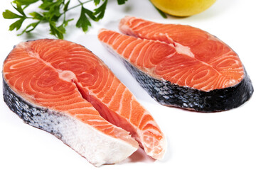 Salmon, slice of fresh raw fish with parsley and lemon, isolated on white background