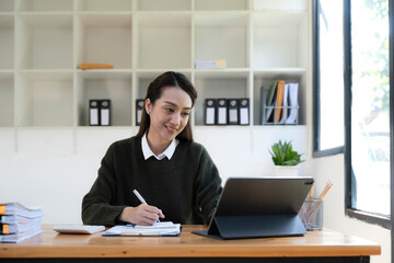 Portrait of an Asian young business Female working on a laptop computer in her workstation.Business people employee freelance online report marketing e-commerce telemarketing concept.