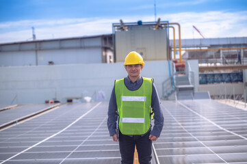 Asian Engineer checking solar power cell energy on rooftop of factory. Asian worker working install solar power solar cell system for using clean solar energy.