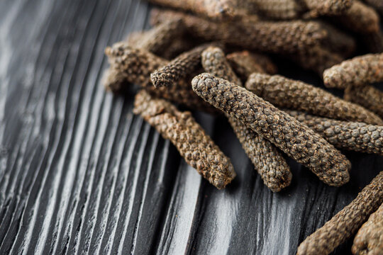 dried aromatic pippali long pepper on black wooden rustic background